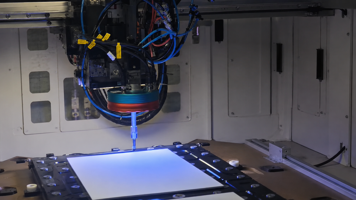 Industrial station applying adhesive along a programmed path