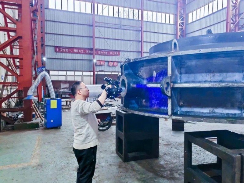 engineer using a blue-light 3D scanner to capture a large casting in a workshop
