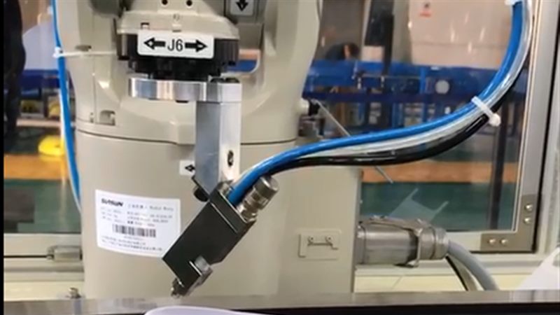 Robot spraying adhesive along a sole contour